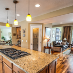 Alabaster granite counter top kitchen island with wood floors.